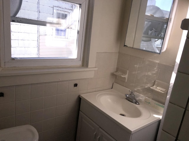 bathroom featuring vanity, tile walls, a wealth of natural light, and backsplash