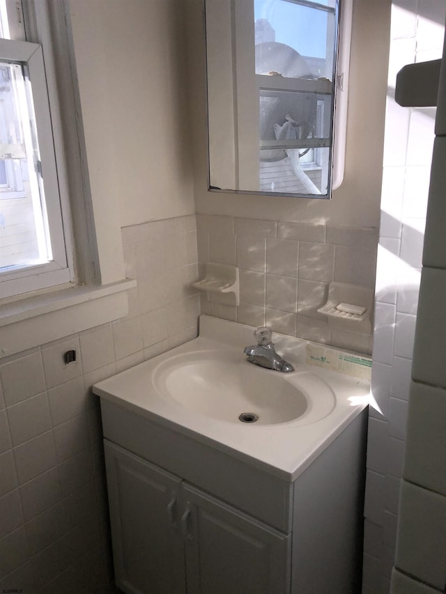 bathroom with tile walls, vanity, and tasteful backsplash