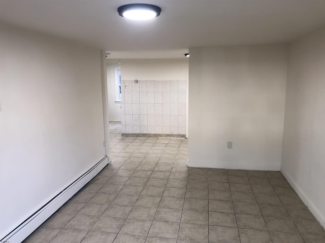 spare room featuring baseboard heating and tile patterned floors