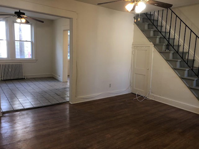 interior space with dark hardwood / wood-style flooring, radiator heating unit, and ceiling fan