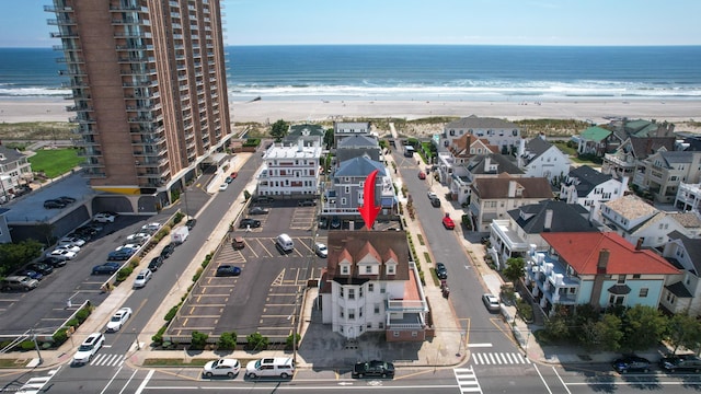 drone / aerial view with a beach view and a water view