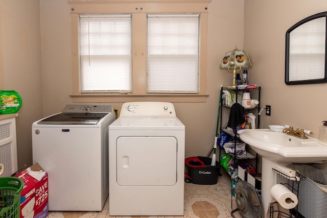 laundry area featuring light tile patterned floors, sink, and washing machine and clothes dryer