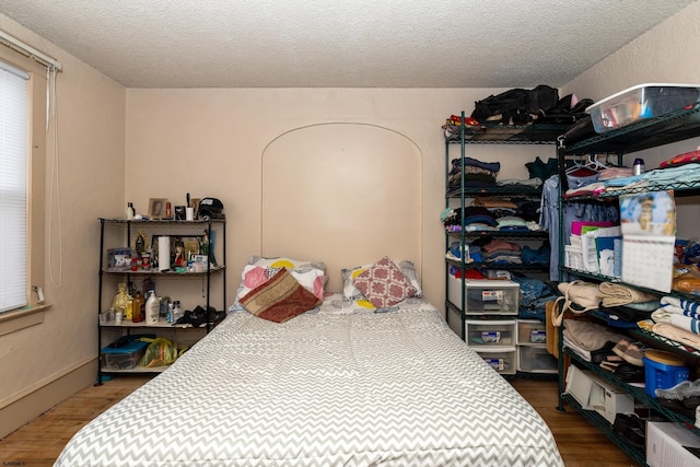 bedroom with a textured ceiling and dark hardwood / wood-style flooring