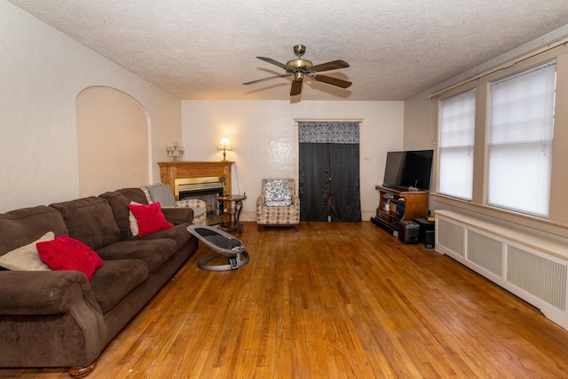 living room featuring ceiling fan, a textured ceiling, hardwood / wood-style flooring, and radiator