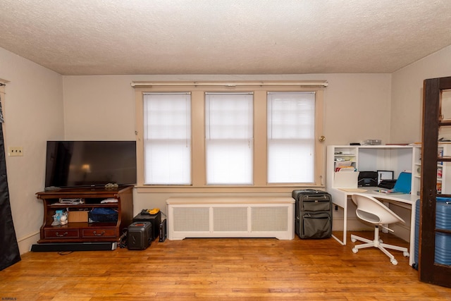 home office featuring radiator, a textured ceiling, and light hardwood / wood-style floors