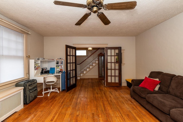 interior space featuring a textured ceiling, radiator heating unit, hardwood / wood-style floors, and french doors