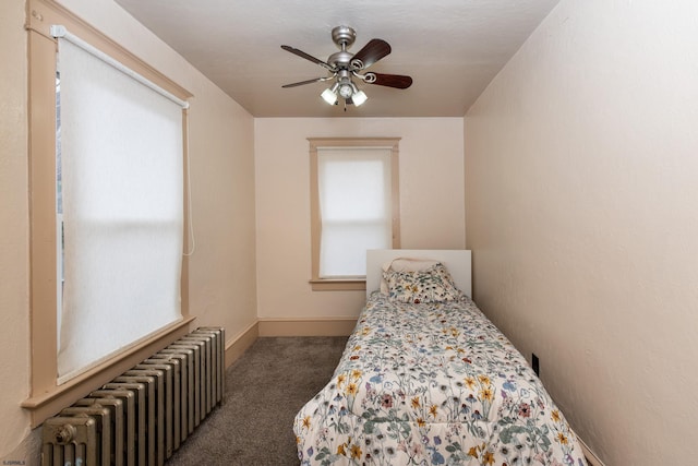 bedroom featuring ceiling fan, dark carpet, and radiator