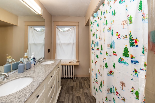 bathroom with radiator, a shower with curtain, wood-type flooring, and vanity