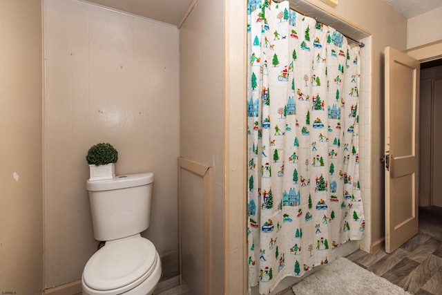 bathroom featuring toilet, hardwood / wood-style flooring, and walk in shower