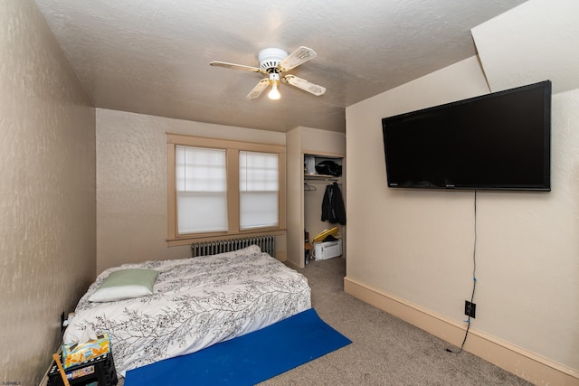 carpeted bedroom with radiator, a closet, a textured ceiling, and ceiling fan