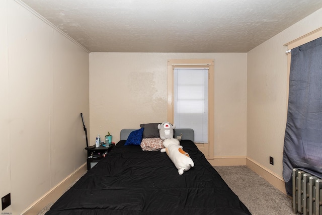 bedroom with a textured ceiling, carpet flooring, and radiator heating unit