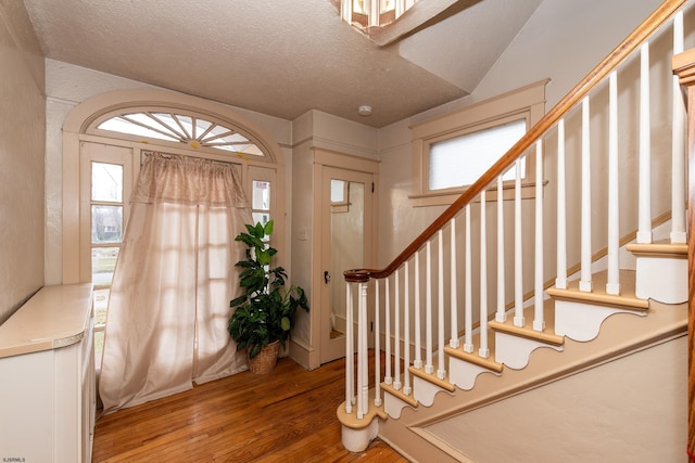 foyer entrance featuring a textured ceiling and hardwood / wood-style flooring