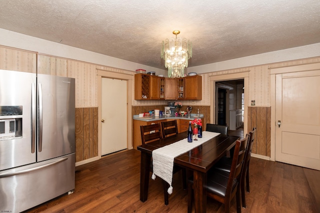 dining area with a textured ceiling, dark hardwood / wood-style floors, and a chandelier