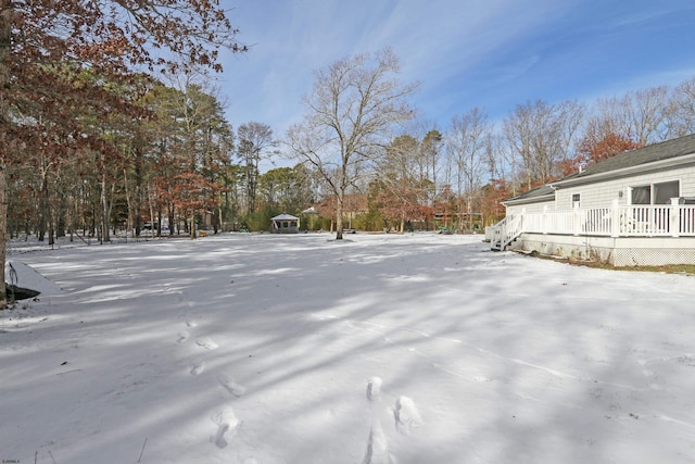 yard covered in snow with a deck