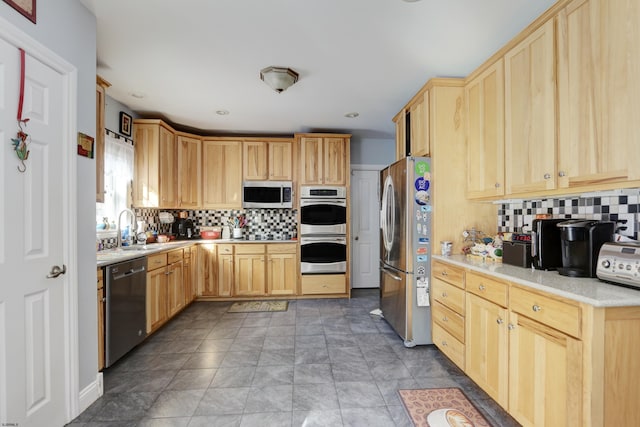 kitchen featuring decorative backsplash, sink, light brown cabinets, and stainless steel appliances