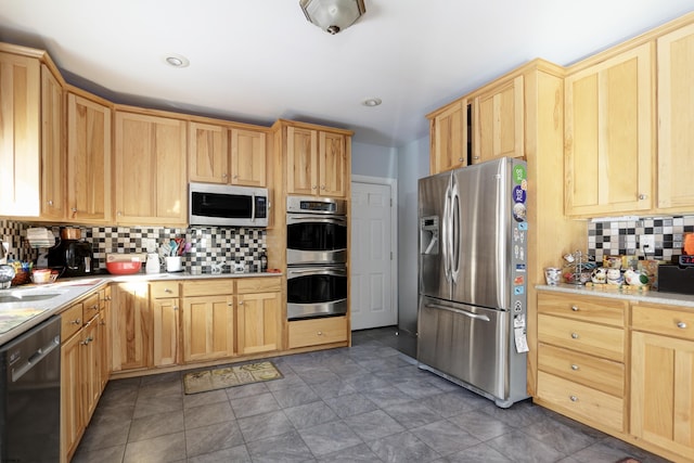 kitchen featuring light brown cabinets, stainless steel appliances, and tasteful backsplash