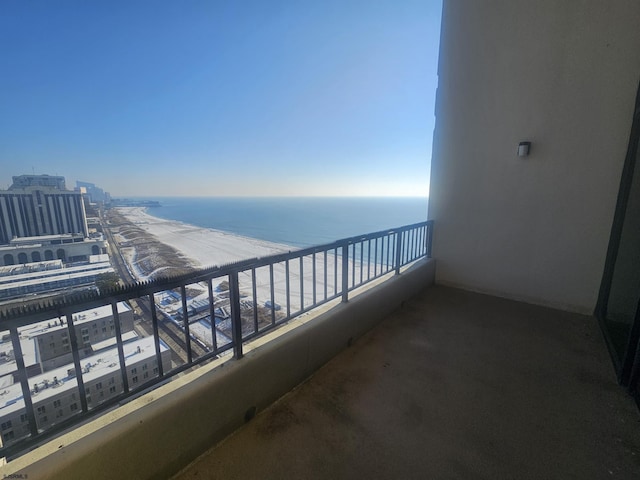 balcony featuring a water view and a beach view