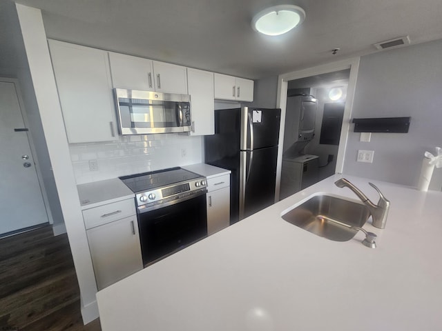 kitchen featuring tasteful backsplash, sink, white cabinetry, appliances with stainless steel finishes, and dark hardwood / wood-style flooring