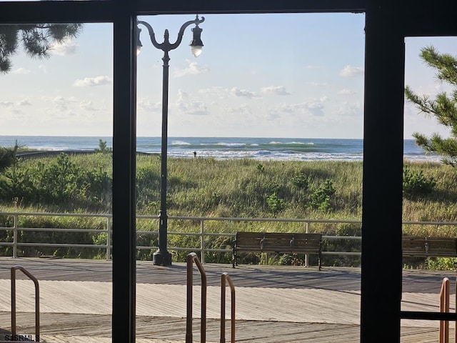 doorway with a water view and a beach view