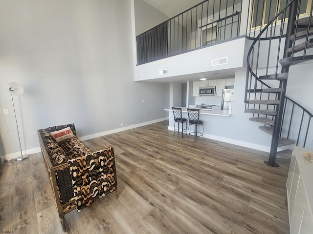 living area with wood-type flooring and a high ceiling