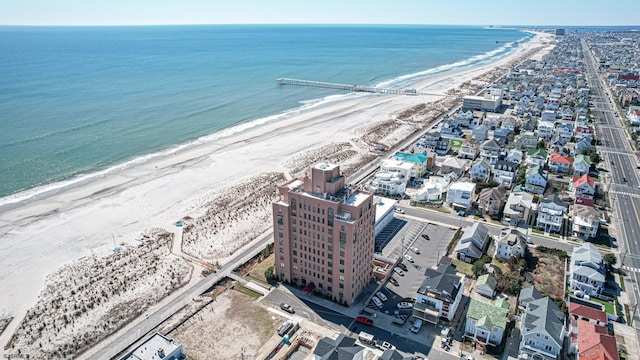 birds eye view of property with a water view and a beach view