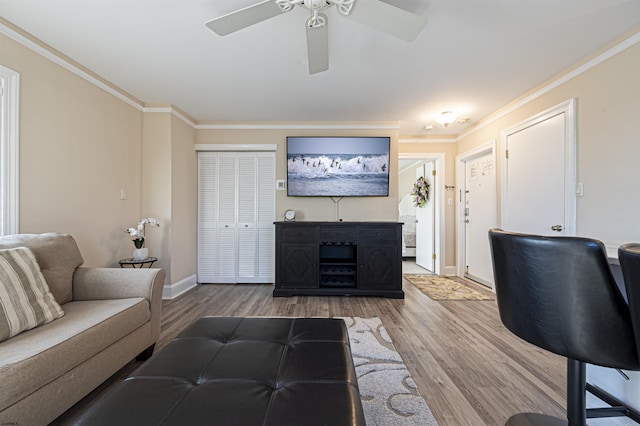 living room with hardwood / wood-style flooring, ornamental molding, and ceiling fan