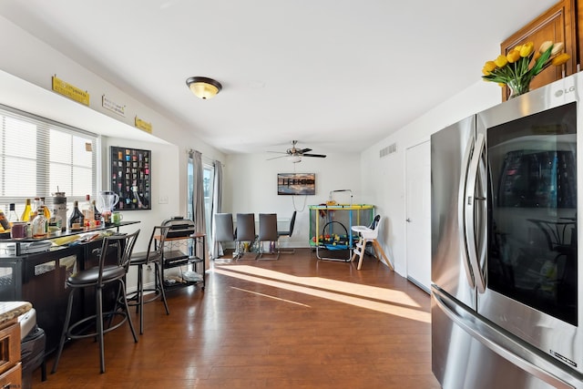 interior space featuring ceiling fan, dark wood-type flooring, and stainless steel fridge