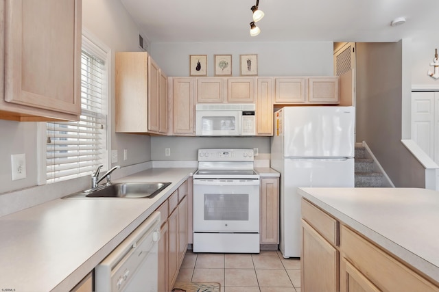 kitchen featuring light brown cabinets, light tile patterned floors, sink, and white appliances