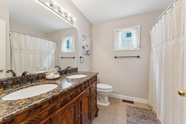 bathroom with toilet, vanity, and tile patterned flooring