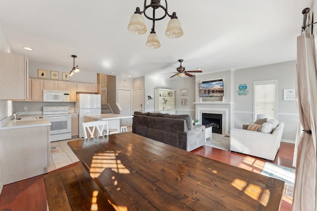 dining space with ceiling fan, sink, and light hardwood / wood-style floors