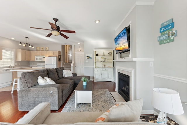 living room with ceiling fan, sink, dark wood-type flooring, and a fireplace