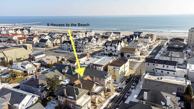 birds eye view of property featuring a beach view and a water view