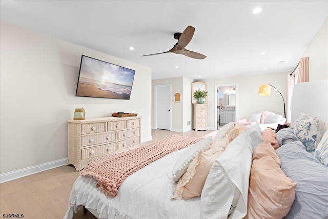 bedroom featuring ceiling fan, ensuite bathroom, and light hardwood / wood-style flooring