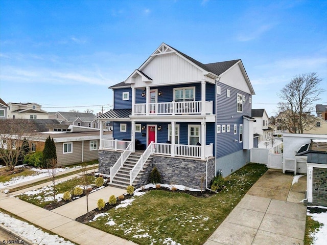 view of front of home with covered porch, a front yard, and a balcony