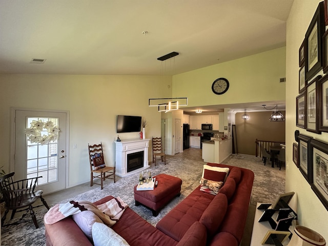 carpeted living room featuring a notable chandelier