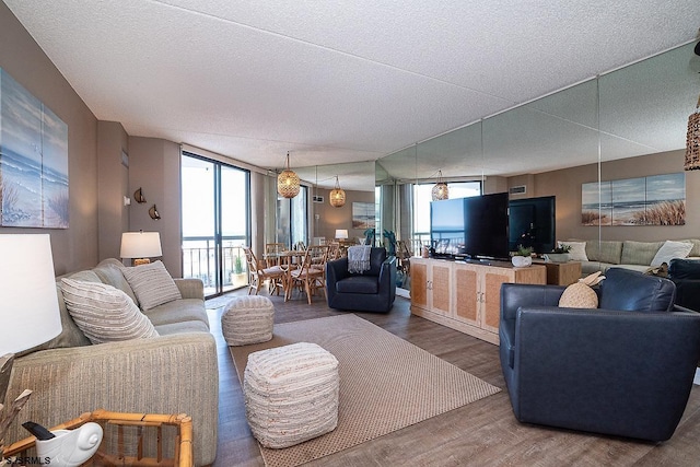 living room with floor to ceiling windows, wood-type flooring, and a textured ceiling