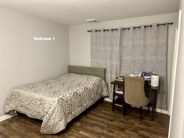 bedroom with dark wood-type flooring