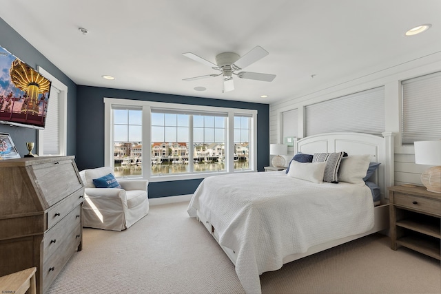 carpeted bedroom with ceiling fan and a water view