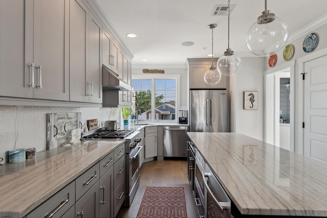 kitchen with a kitchen island, sink, high end appliances, light stone countertops, and gray cabinetry