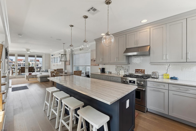 kitchen featuring ceiling fan, hanging light fixtures, gray cabinets, and stainless steel stove