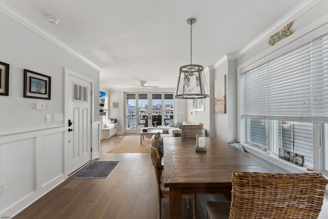 dining space featuring ceiling fan, plenty of natural light, wood-type flooring, and ornamental molding