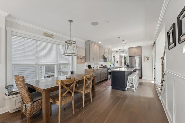 kitchen with stainless steel appliances, gray cabinetry, dark hardwood / wood-style floors, a kitchen island, and pendant lighting