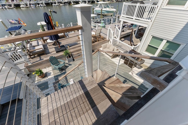 wooden deck with a boat dock and a water view