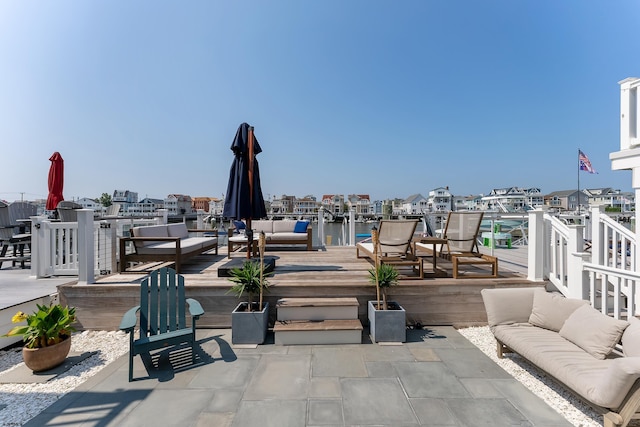 wooden terrace featuring a water view and an outdoor living space