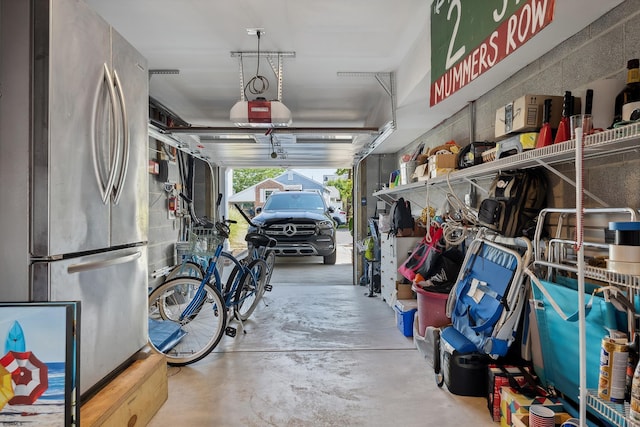 garage featuring a garage door opener and stainless steel fridge