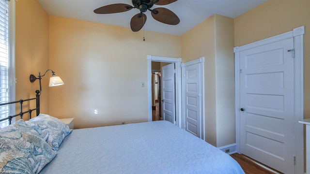 bedroom with ceiling fan, dark hardwood / wood-style flooring, and a closet