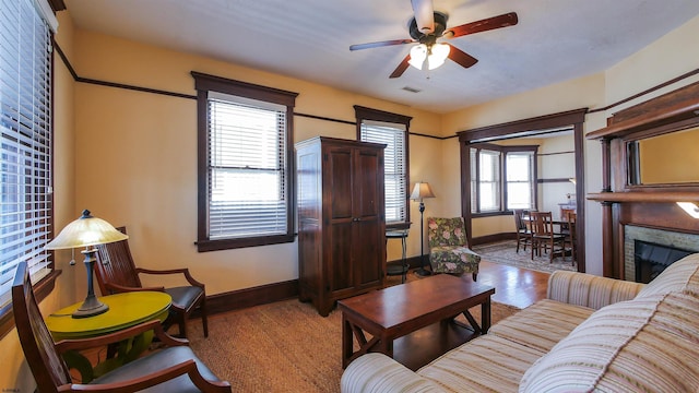 living room featuring ceiling fan, a fireplace, and hardwood / wood-style floors