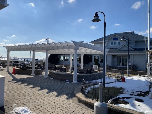 snow covered patio with a pergola