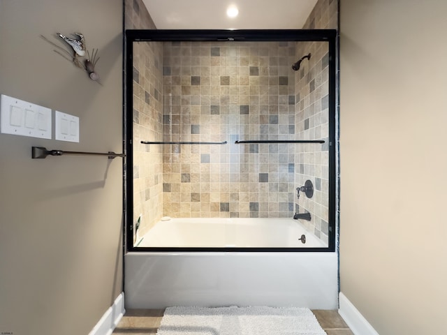 bathroom with combined bath / shower with glass door and tile patterned flooring