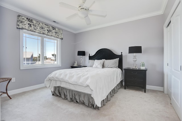 bedroom featuring ceiling fan, ornamental molding, a closet, and light colored carpet